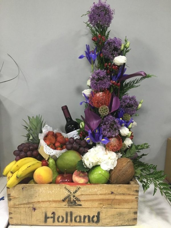 Centro de flores, frutas y vino negro